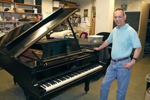 Grijalva poses with the unrestored Gershwin piano shortly after its arrival. Courtesy photo